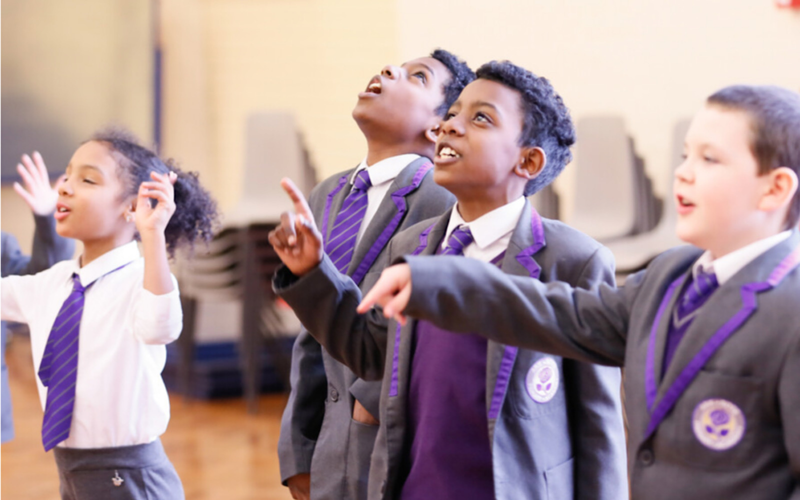 Some children in grey and purple school uniform art taking part in a workshop