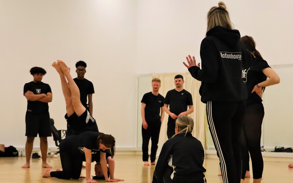 Motionhouse students take part in a workshop in Warwickshire and two of them are balancing on each other