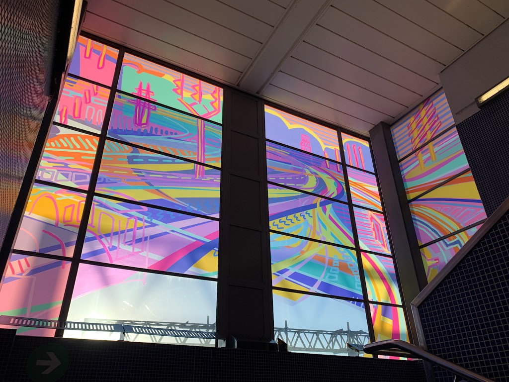 A window designed by artist Alisha Miller has illustrations of streets and shapes in bright colours