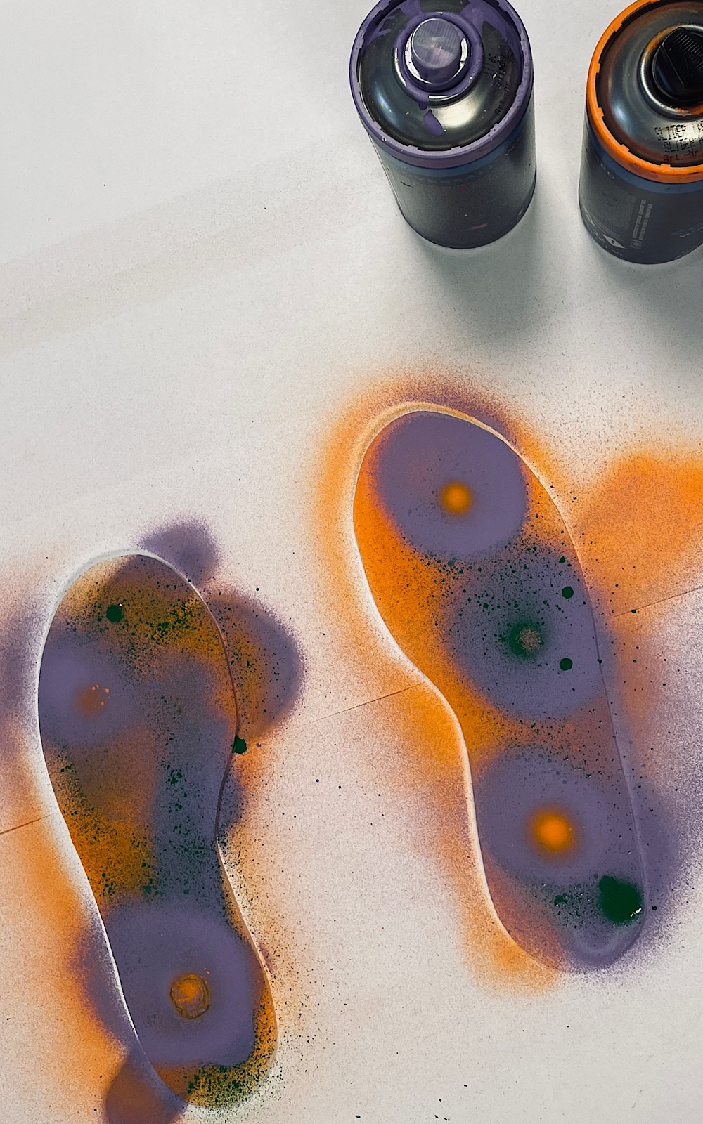 Orange and purple spray paint on a white canvas