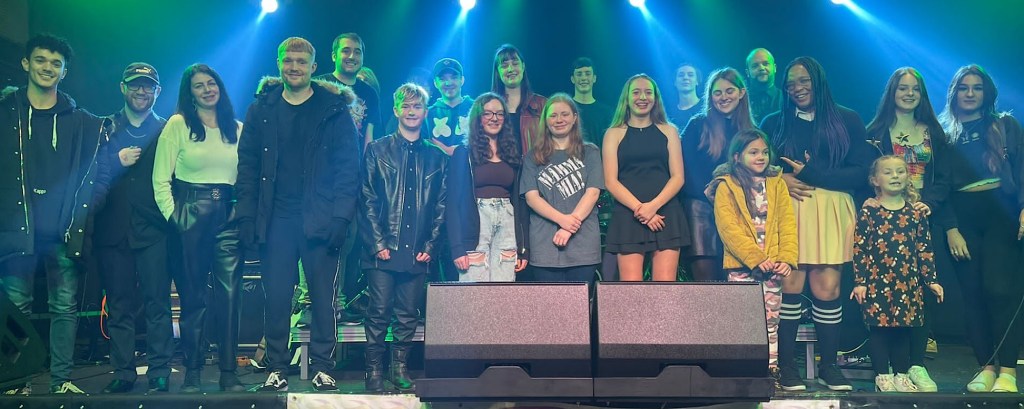 A group of young people on students stand together on a stage