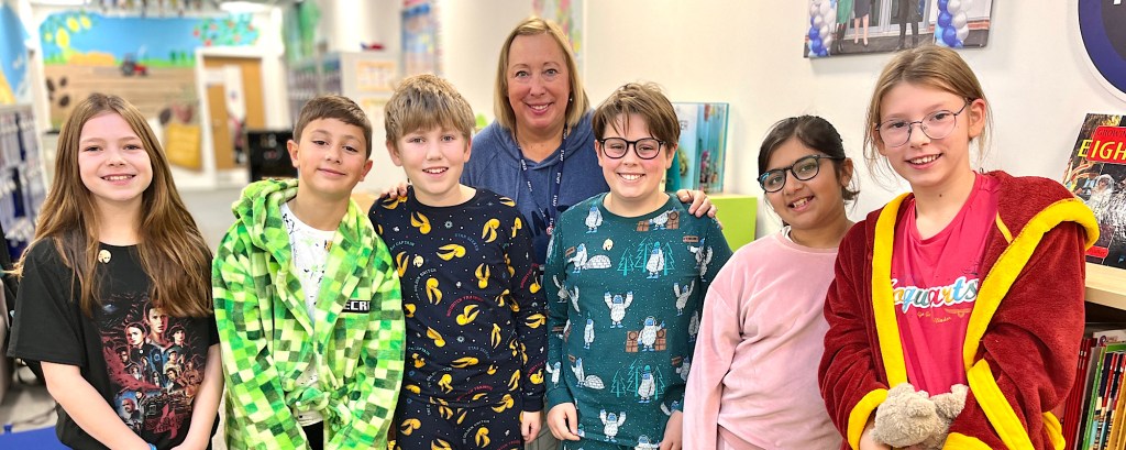Six students stand with their teacher and they all smile to the camera