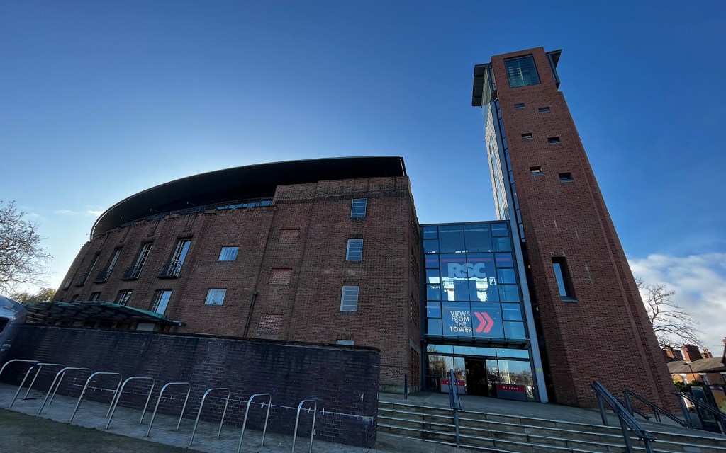 A large red brick theatre building with blue sky in the background