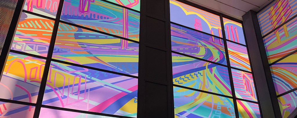 A window designed by artist Alisha Miller has illustrations of streets and shapes in bright colours