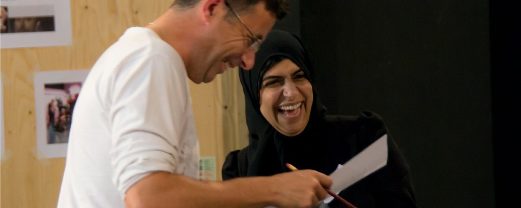 Two teachers take part in a workshop, they both laugh and one looks at a sheet of paper
