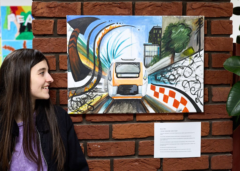 A painting of a train with the artist stood in front