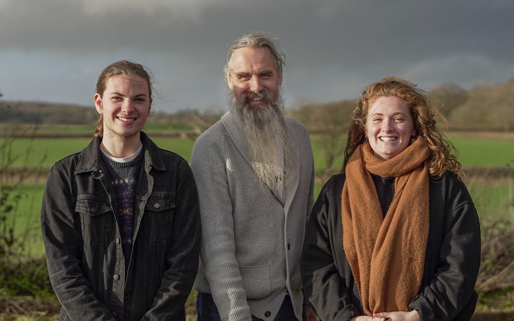 Three people smile to the camera