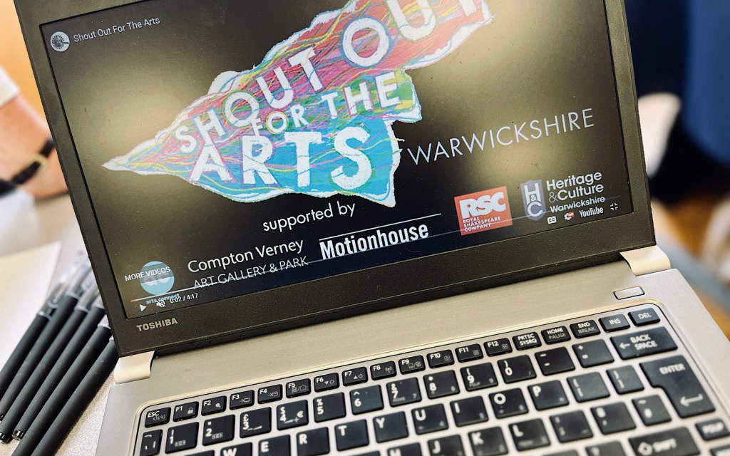 A laptop shows a film at a student fair