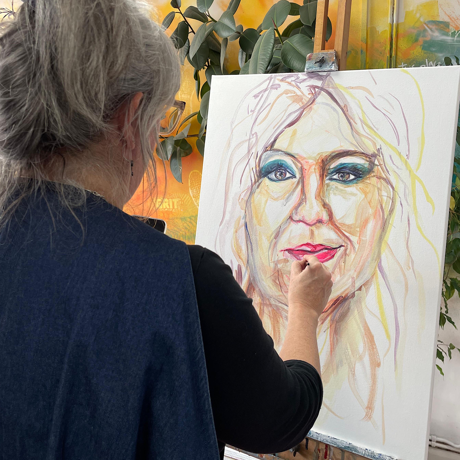 An artist paints a face on a canvas