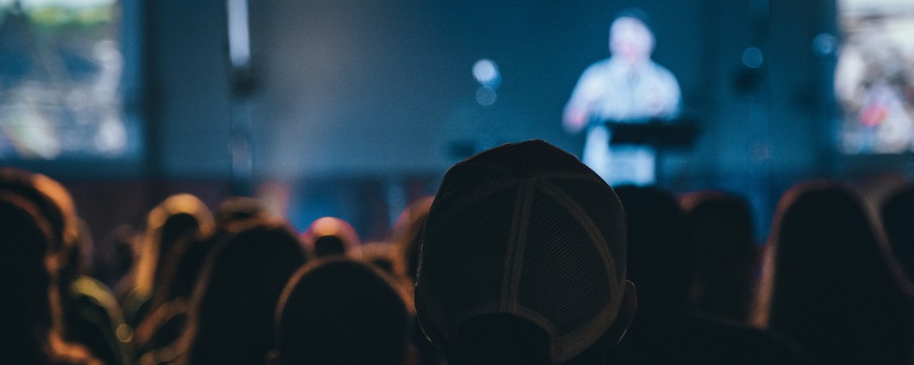 A speaker talking on stage at a jobs fair