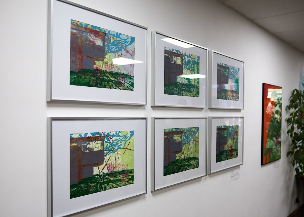 Six paintings framed on a wall