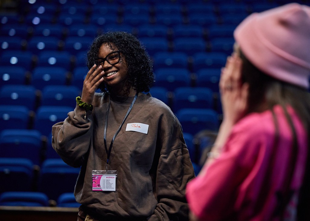 A young person laughs whilst taking part in a physical theatre dance workshop