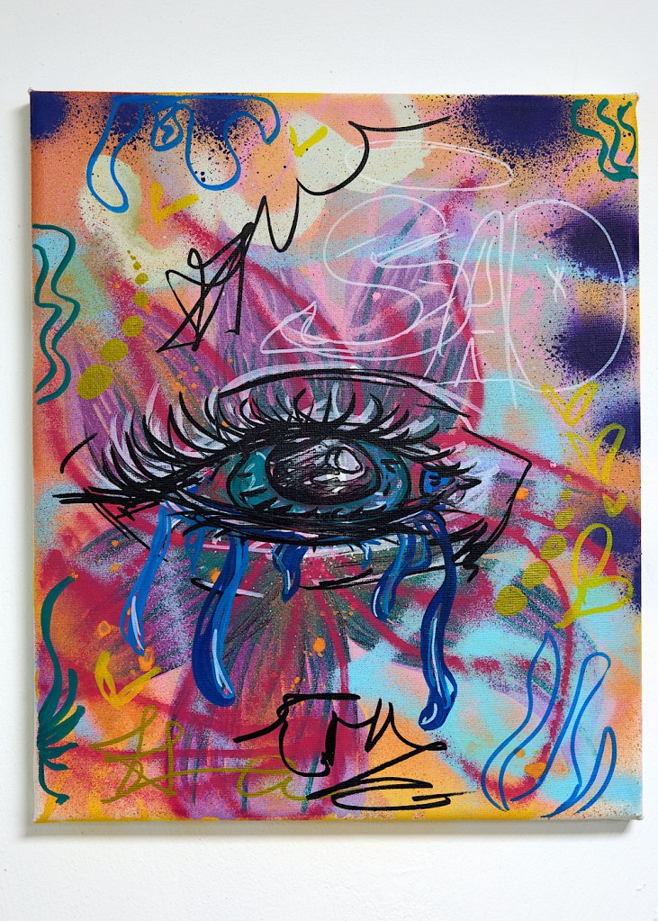 A graffiti style painting of an eye with lots of bright colours in the background