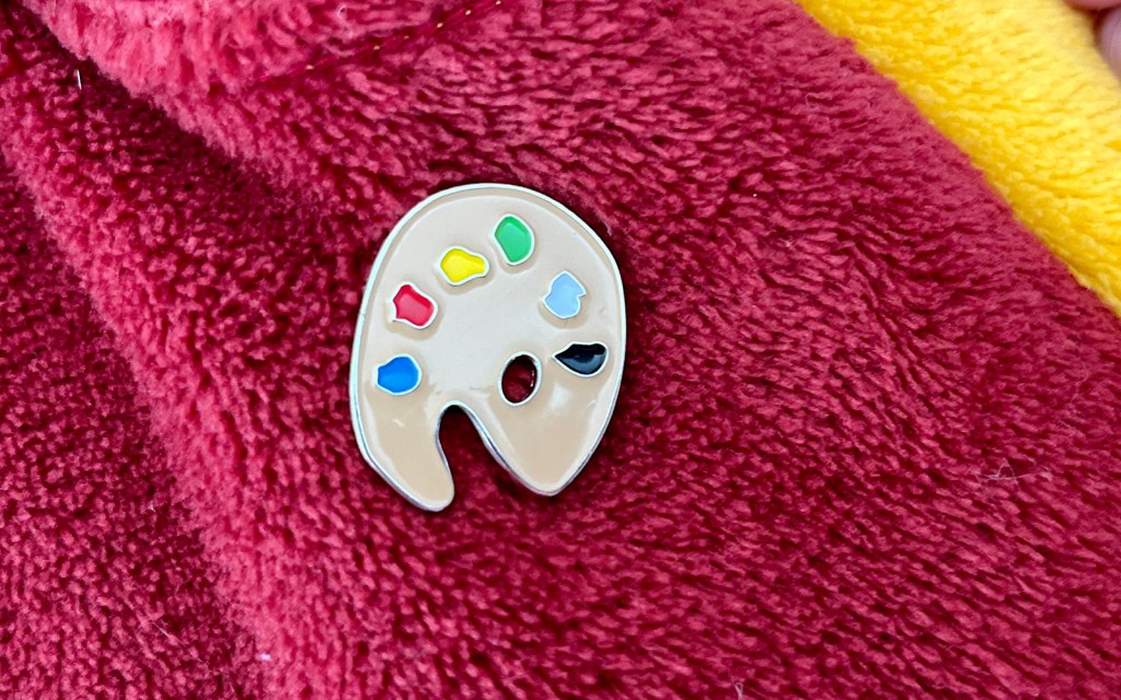 A metal badge of an art palette