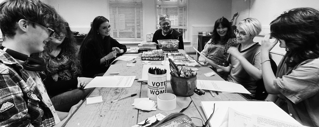 A group of artist sit at a table