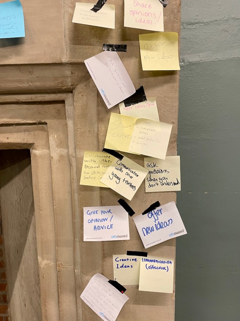 Lots of yellow and pink post its are stuck to a stone fireplace