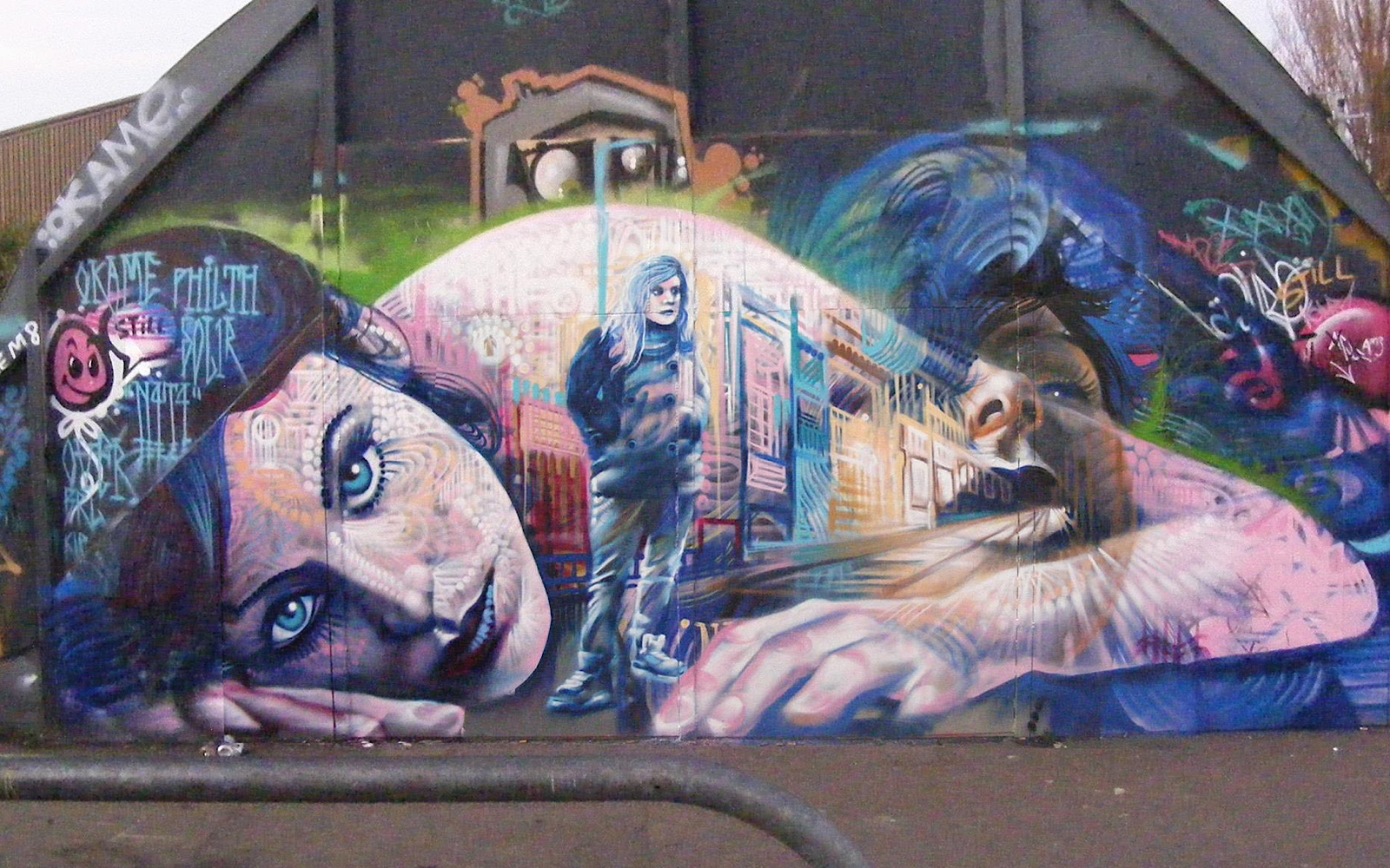 A piece of street art shows a woman lying on the floor