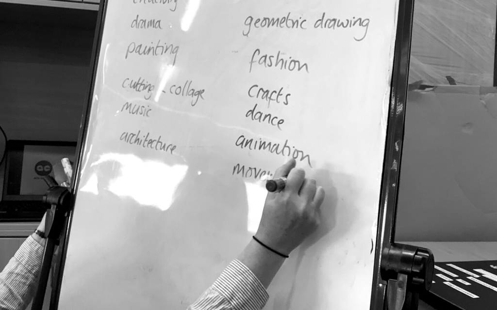 A practitioner writes on a white board with a pen