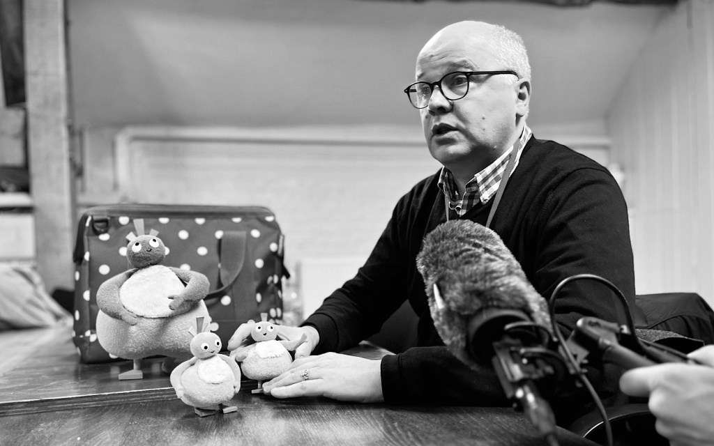 A man talks into a microphone as part of a podcast recording