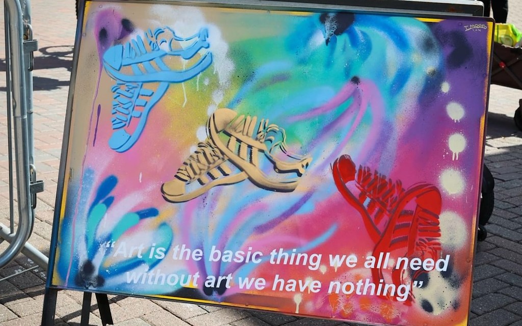 A piece of colourful artwork says: art is a basic thing we all need, without art we have nothing