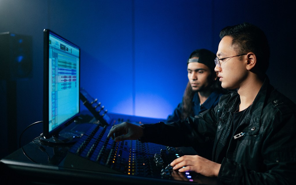 Two students sit at a mixing desk