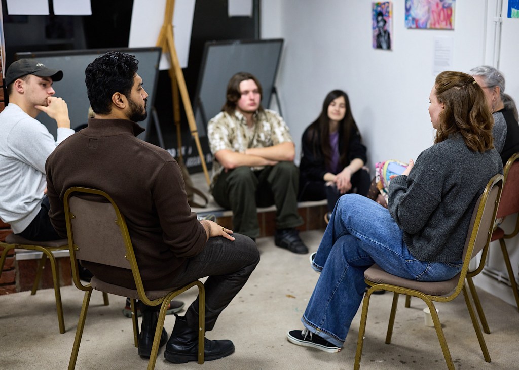 A room of six young people who are discussing ideas