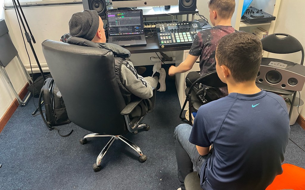 Students sit at a computer and work on something together