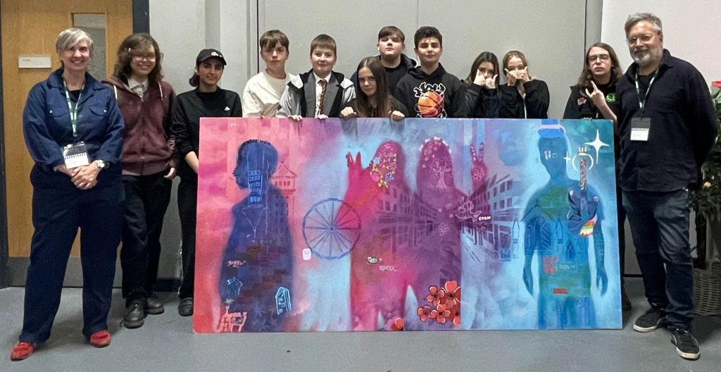 Artists stand next to their finished piece of work